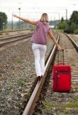 10333836-rear-view-of-woman-with-luggage-walking-on-rail.jpg